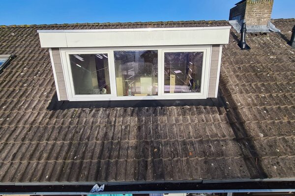 Dakkapel geplaatst op woonhuis met blauwe lucht