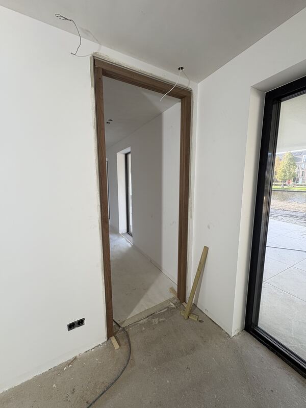 Houten deuromlijsting in een woning naast een glazen pui