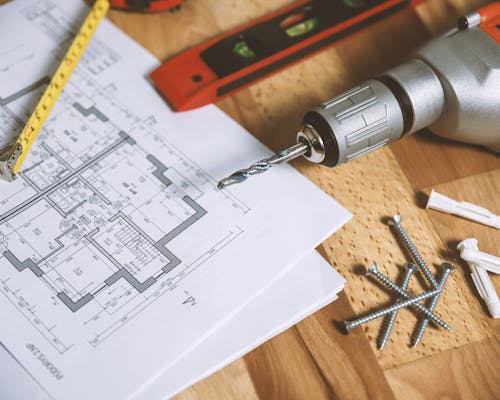 Bouwtekeningen en gereedschap op werkbank